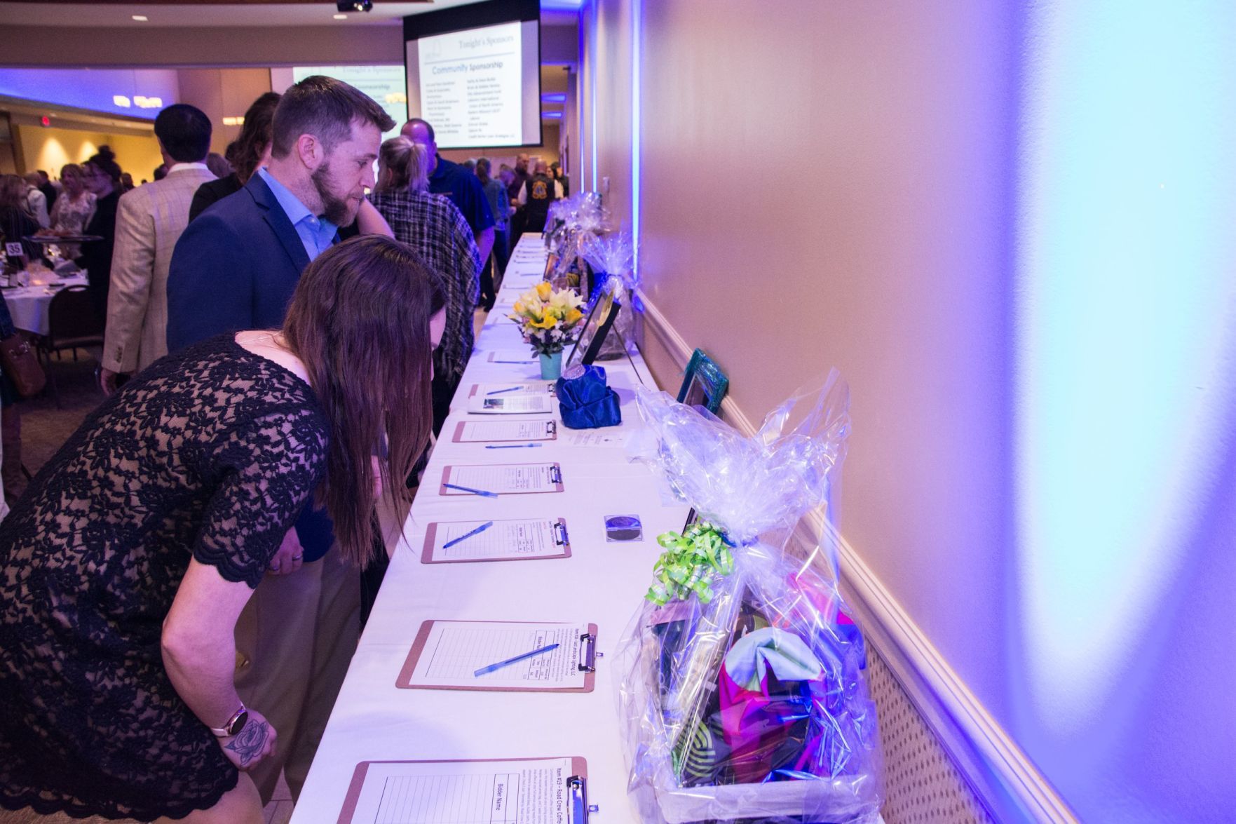 Attendees look at silent auction items